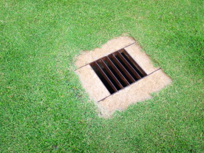 an overhead shot of a grate in a lawn