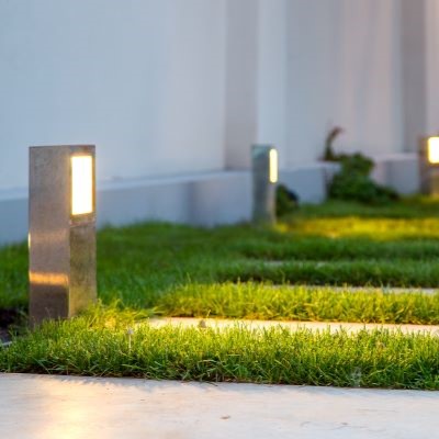 Outdoor landscape lights illuminating a front yard. Wondering how to design your landscape lighting in Florida? Call BrightWater today!